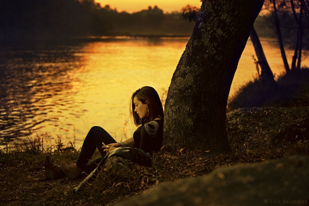 Девушка сидит на берегу