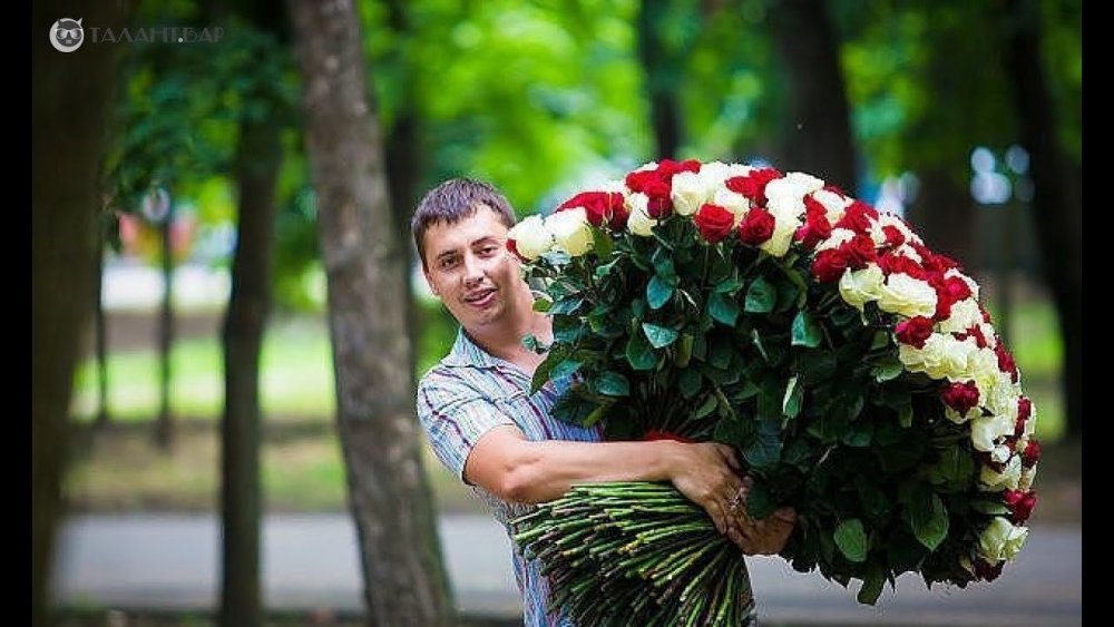 Человек держит огромный букет