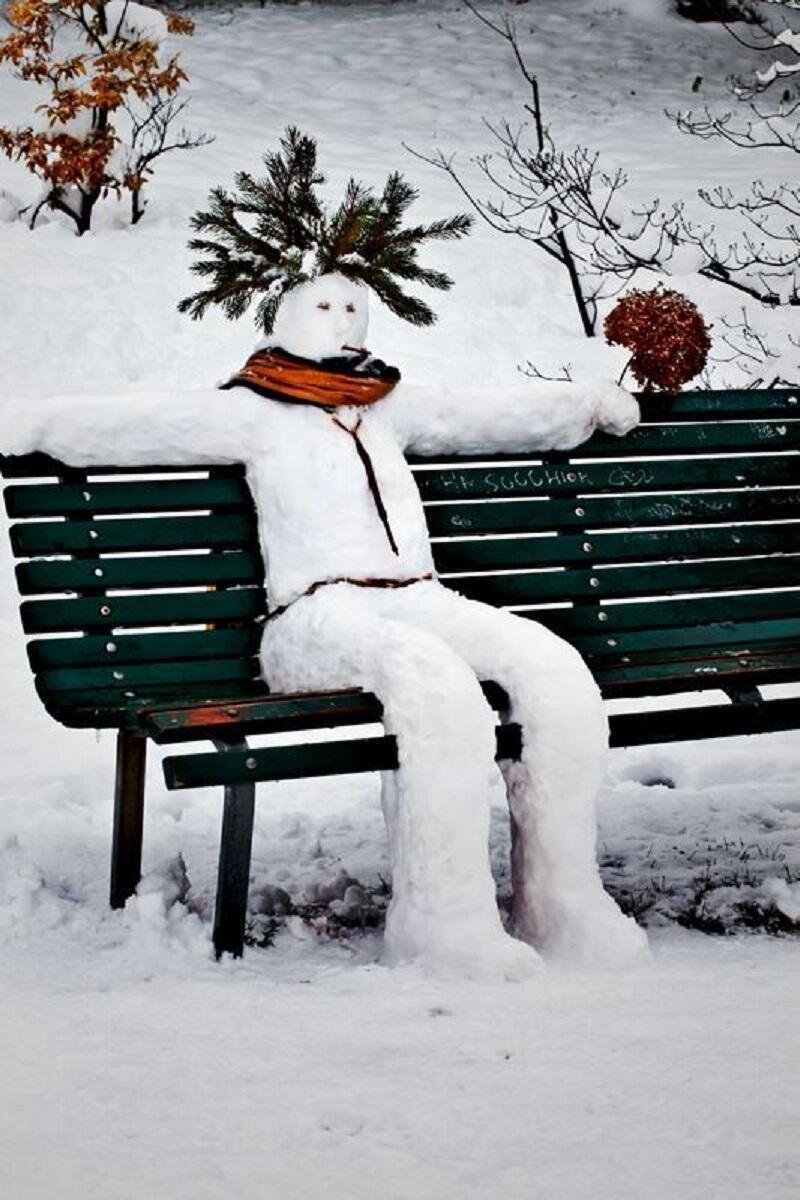 Снеговик сидит на скамейке